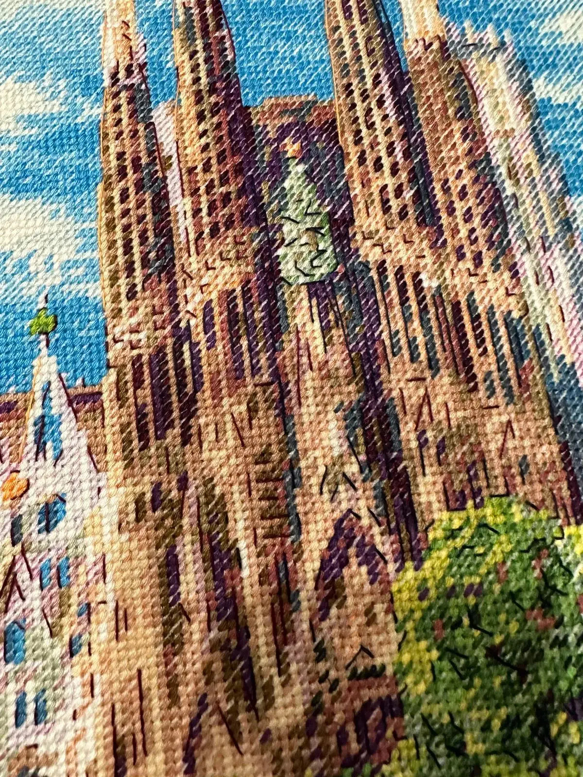 Kit de punto de cruz RIOLIS “Sagrada Familia” con vista detallada de la basílica de Gaudí y el parque frontal, diseño arquitectónico y paisajístico.