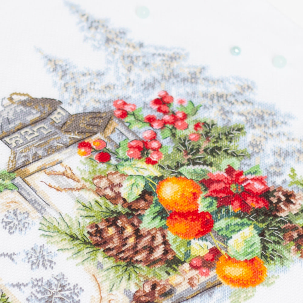 Bordado en punto de cruz de farolillo con plantas de navidad, piñas y un pequeño pájaro de campo de Magic Needle