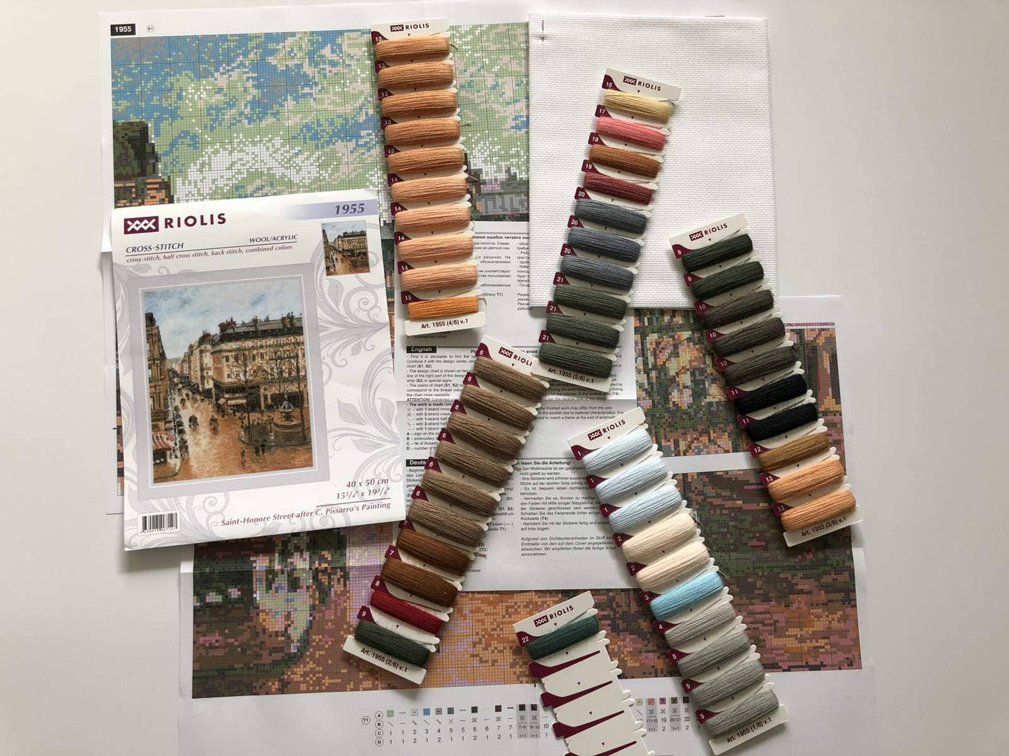Kit de punto de cruz RIOLIS “Calle Saint-Honoré Pissarro” con calle y plaza francesa, fuente central y carruajes tirados por caballos, estilo principios del siglo XX.