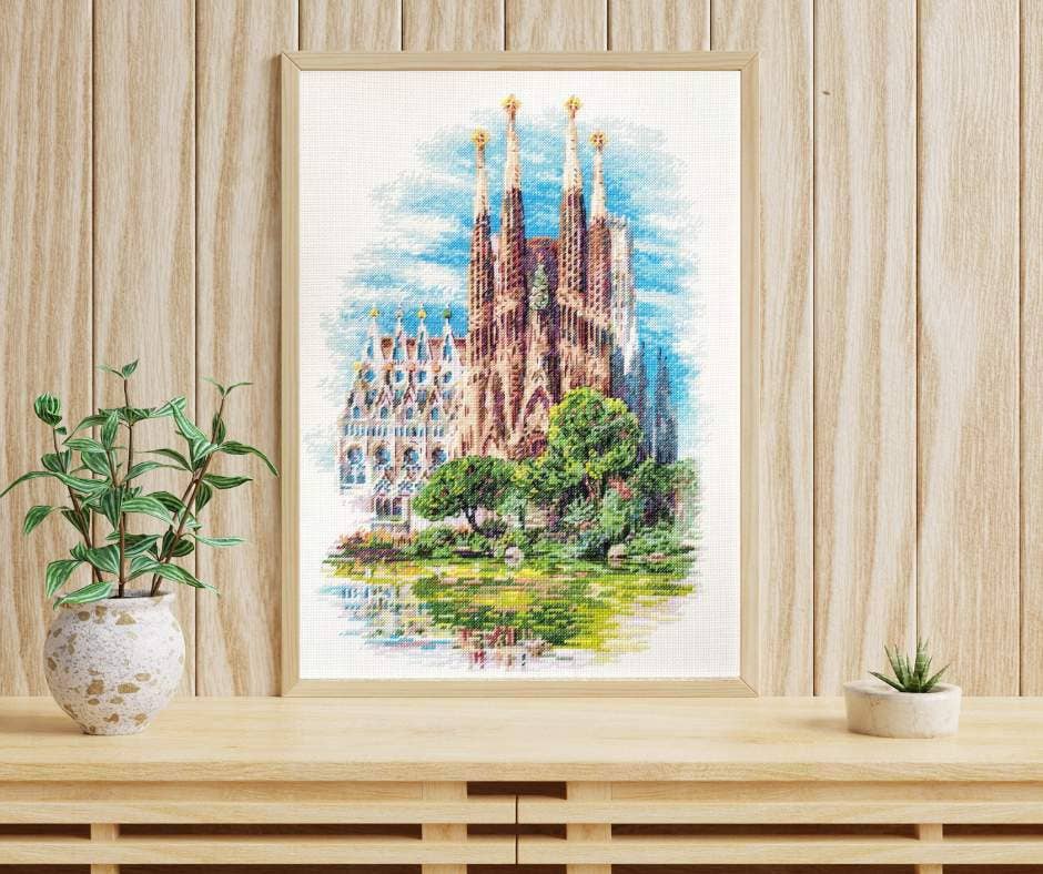 Kit de punto de cruz RIOLIS “Sagrada Familia” con vista detallada de la basílica de Gaudí y el parque frontal, diseño arquitectónico y paisajístico.
