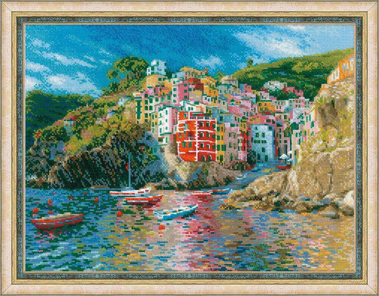 Kit de punto de cruz RIOLIS Liguria con paisaje costero italiano de casas de colores y barcas sobre el mar, incluye tela Aida, hilos, aguja e instrucciones.