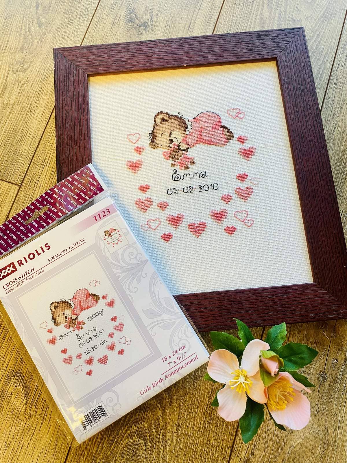Kit de punto de cruz RIOLIS “Anuncio Nacimiento Niña” con osito rosa dormido y corazones, personalizable con nombre y datos del nacimiento.