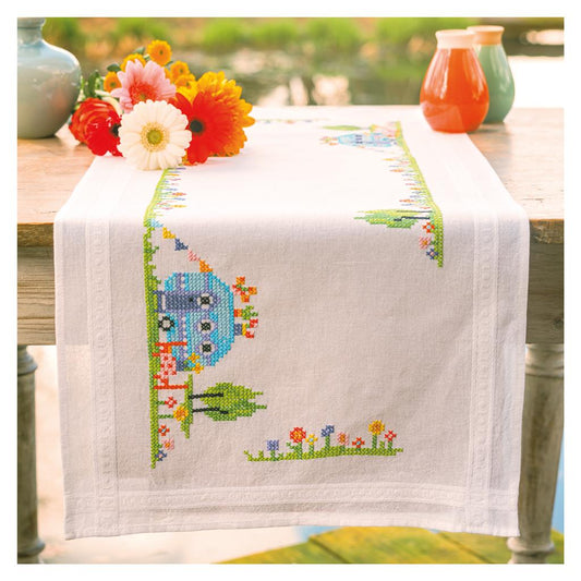 Kit camino de mesa en punto de cruz de Vervaco con diseño veraniego con flores y una caravana azul. Incluye tela preimpresa 100% algodón, hilos DMC y patrón detallado