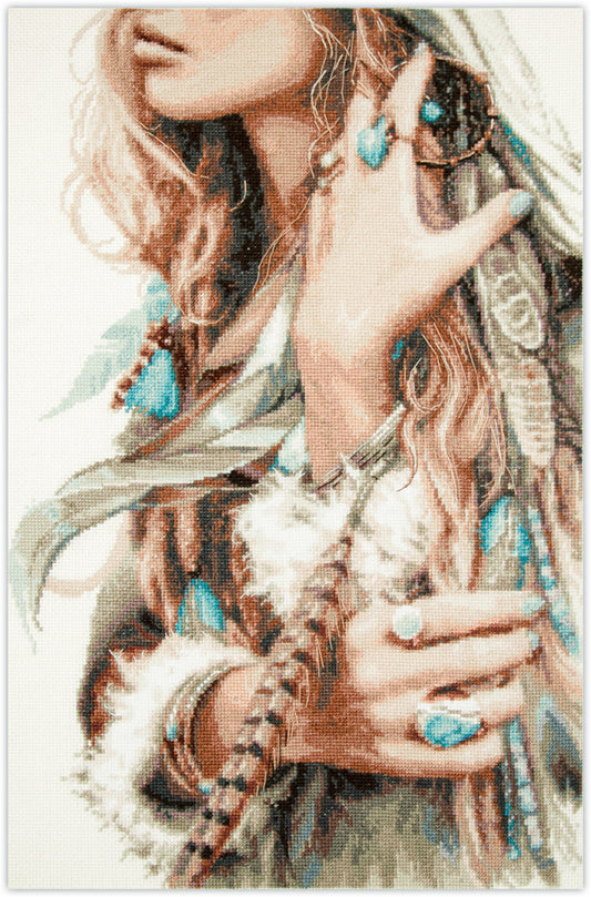Kit de punto de cruz Magic Needle “Boho Girl” con diseño de mujer bohemia, plumas y joyas turquesa. Incluye tela Aida, hilos y aguja.
