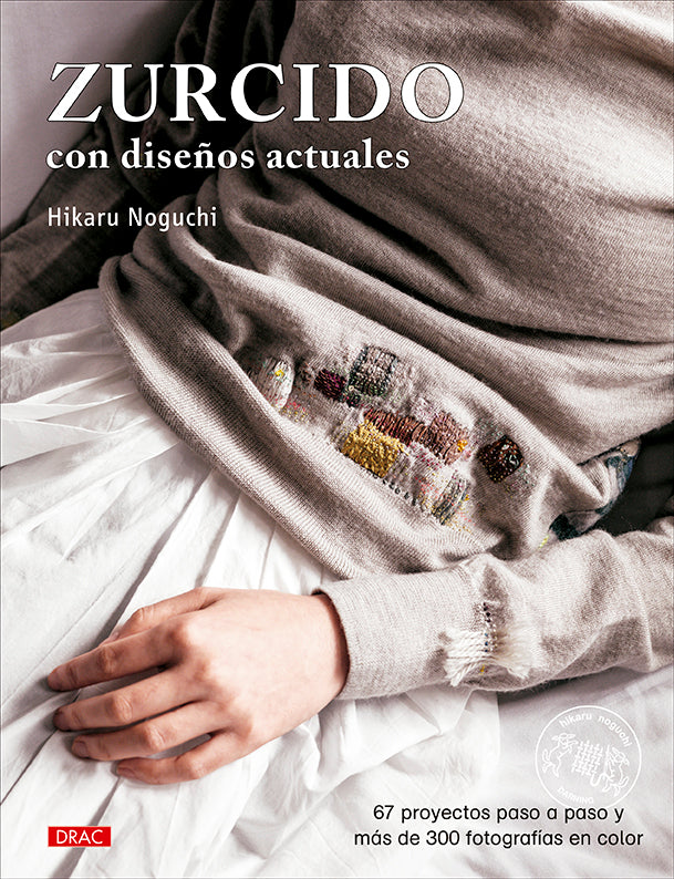 Libro Zurcido con Diseños Actuales de Hikaru Noguchi: portada con un jersey gris reparado con zurcidos visibles de colores sobre sábanas blancas