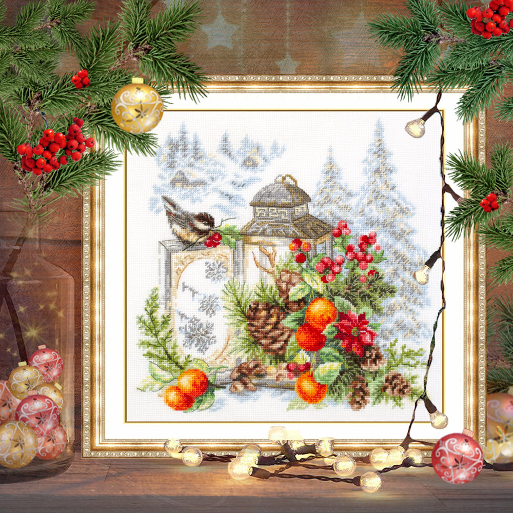 Cuadro Bordado en punto de cruz de farolillo con plantas de navidad, piñas y un pequeño pájaro de campo de Magic Needle