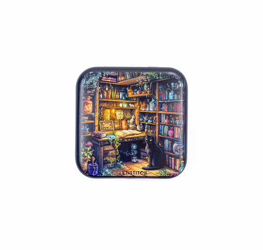 Caja magnética para agujas Letistitch Charmed Library con diseño de biblioteca mágica iluminada y un gato negro sobre fondo de libros.