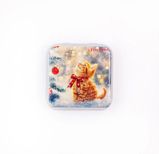 Caja magnética para agujas Letistitch Merry Meow con diseño navideño de gato con lazo rojo junto a un árbol decorado.
