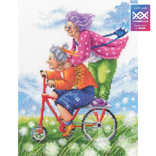 Kit de punto de cruz RTO "Sueño de Vacaciones de las Abuelitas" con dos abuelas en bicicleta entre flores. Incluye tela Zweigart, hilos DMC, aguja e instrucciones.