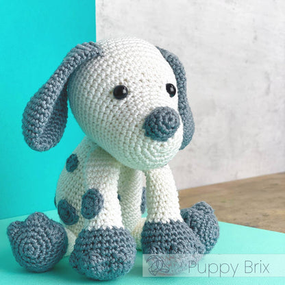 Kit de ganchillo Hardicraft Cachorro Brix con amigurumi de perrito tejido en algodón orgánico blanco y gris, ideal como regalo o decoración infantil.