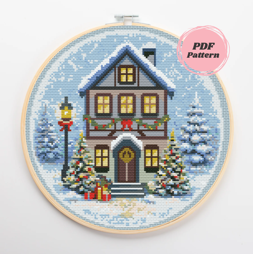 Patrón de punto de cruz de una acogedora casa nevada con decoración navideña
