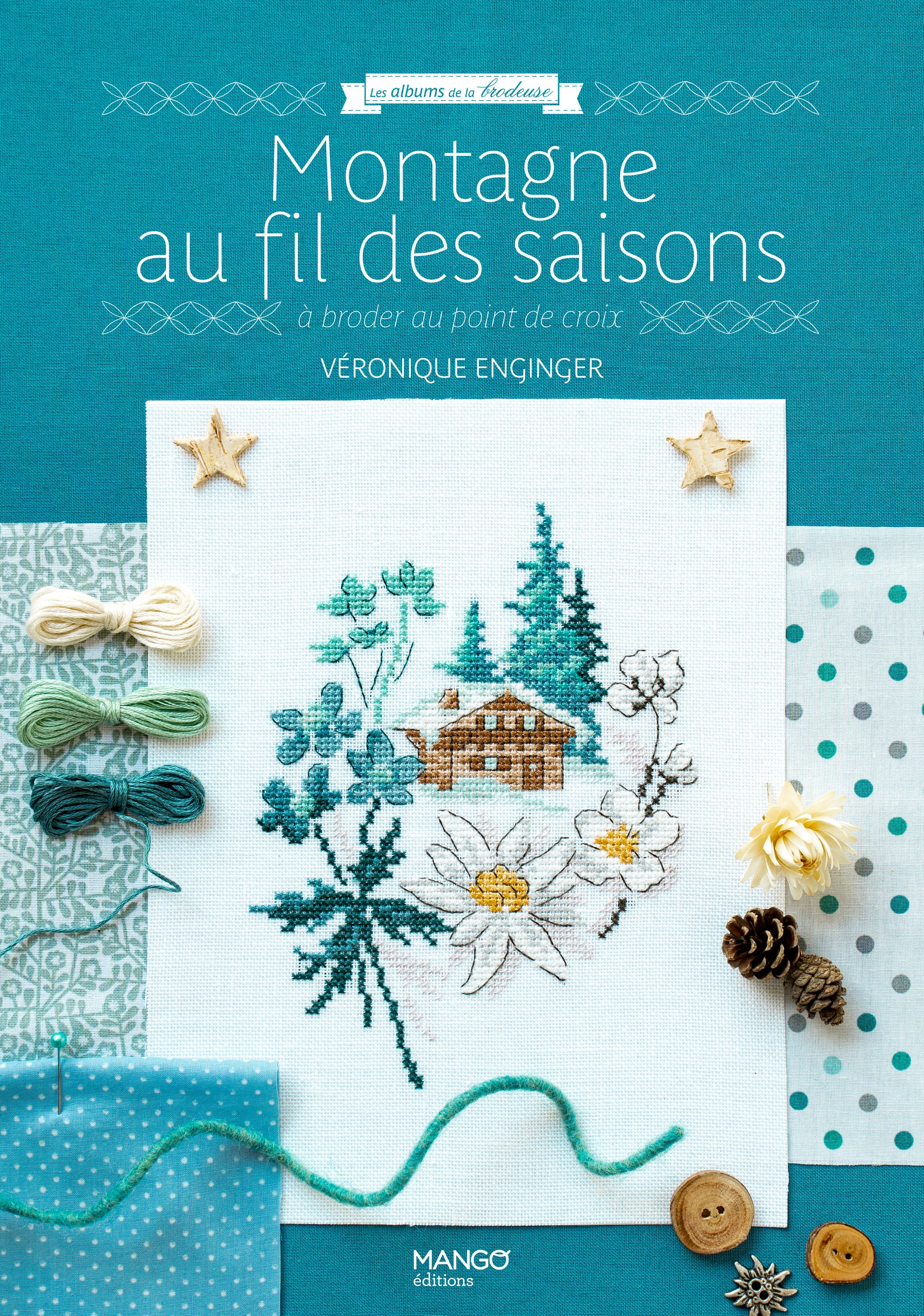 Portada del libro “Montagne au fil des saisons” de Véronique Enginger (Mango Éditions): 20 patrones alpinos en punto de cruz con chalets, flores y pinos, estilo retro.