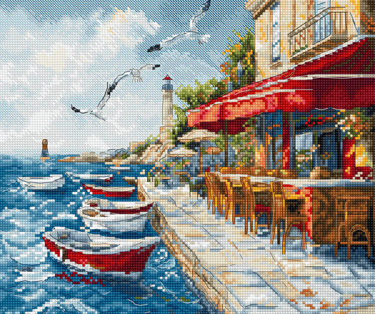 Kit de punto de cruz Letistitch Harbor Breeze con barcas rojas en puerto mediterráneo, gaviotas, faro al fondo y terraza de restaurante con toldo rojo.