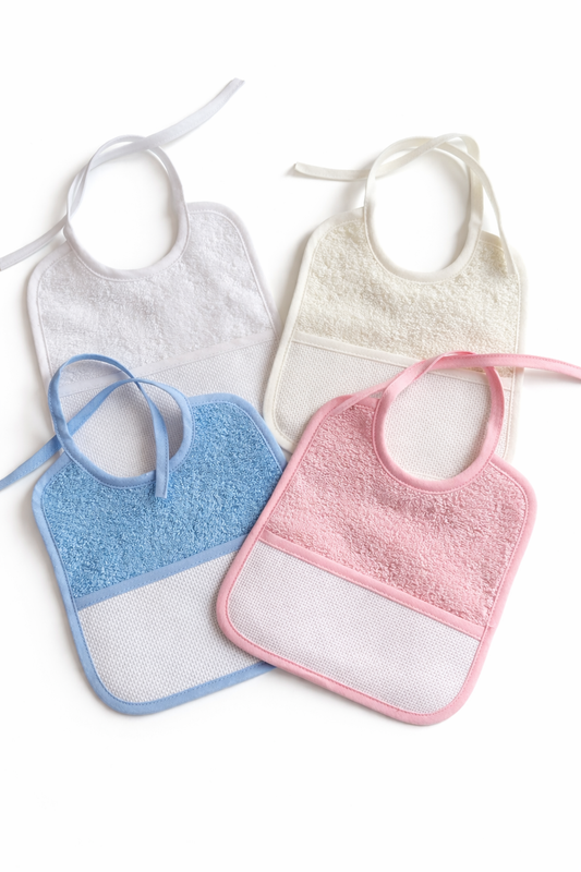 Baberos para bordar en punto de cruz BM Ricami en colores rosa, azul, beige y blanco con tela Aida 14 ct y zona personalizable para bebé.