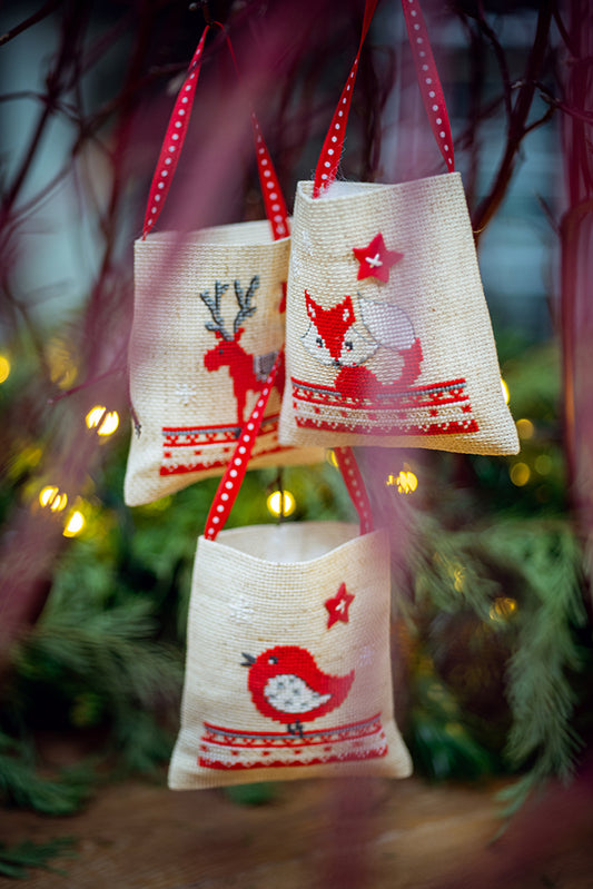 Kit de punto de cruz fácil Vervaco con tres bolsitas de regalo navideñas, diseño de zorro, pájaro y reno en tonos rojos, ideal para principiantes.
