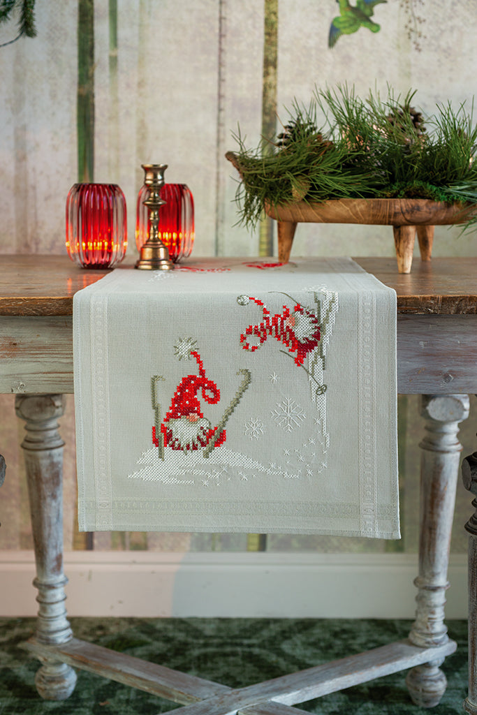 Camino de mesa en punto de cruz Vervaco Gnomos Esquiando bordado sobre tela de algodón con escena invernal.