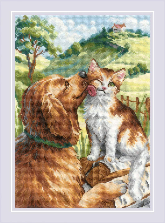Kit de punto de cruz Riolis Como Gato y Perro, diseño adorable de golden retriever lamiendo a un gato tricolor sobre pradera verde, incluye tela Aida, hilos y aguja.