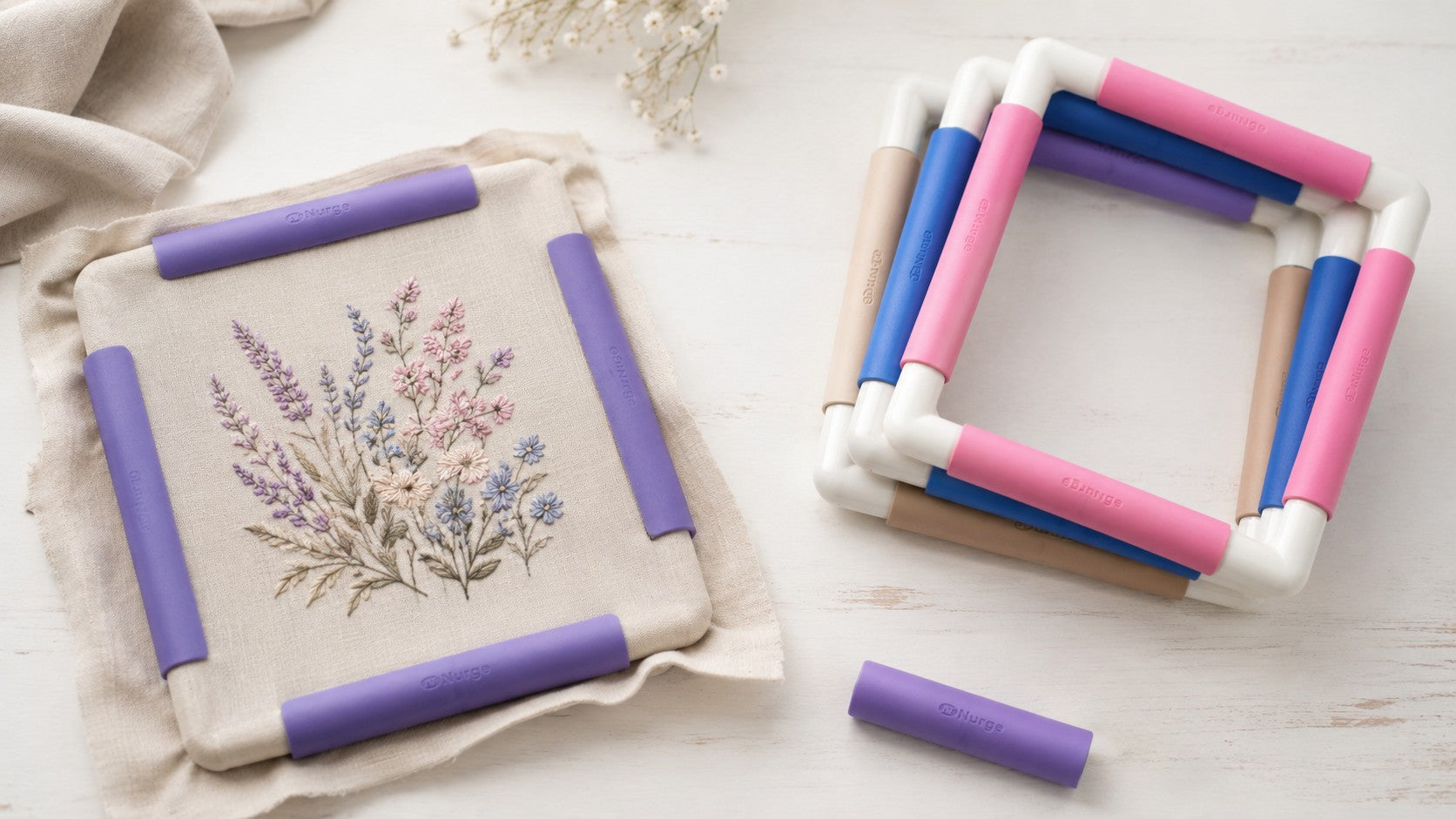 Bastidores Snap Frame Nurge para bordado y punto de cruz en colores morado, rosa, azul y beige con tela montada y clips de sujeción