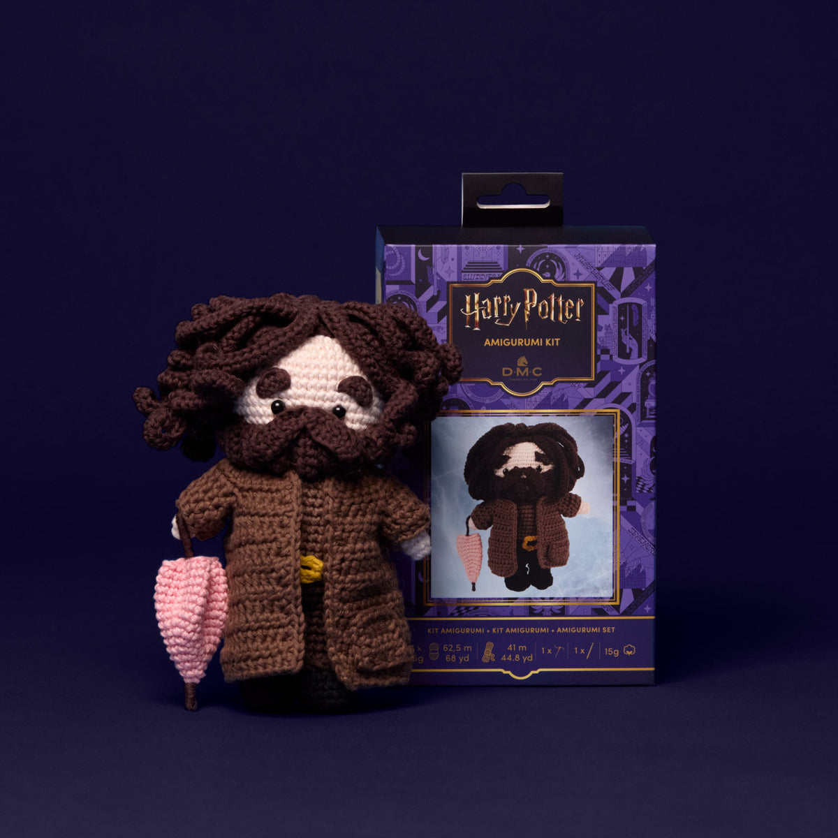 Kit amigurumi Harry Potter DMC con el muñeco de Hagrid tejido a crochet con barba, abrigo marrón y paraguas rosa.