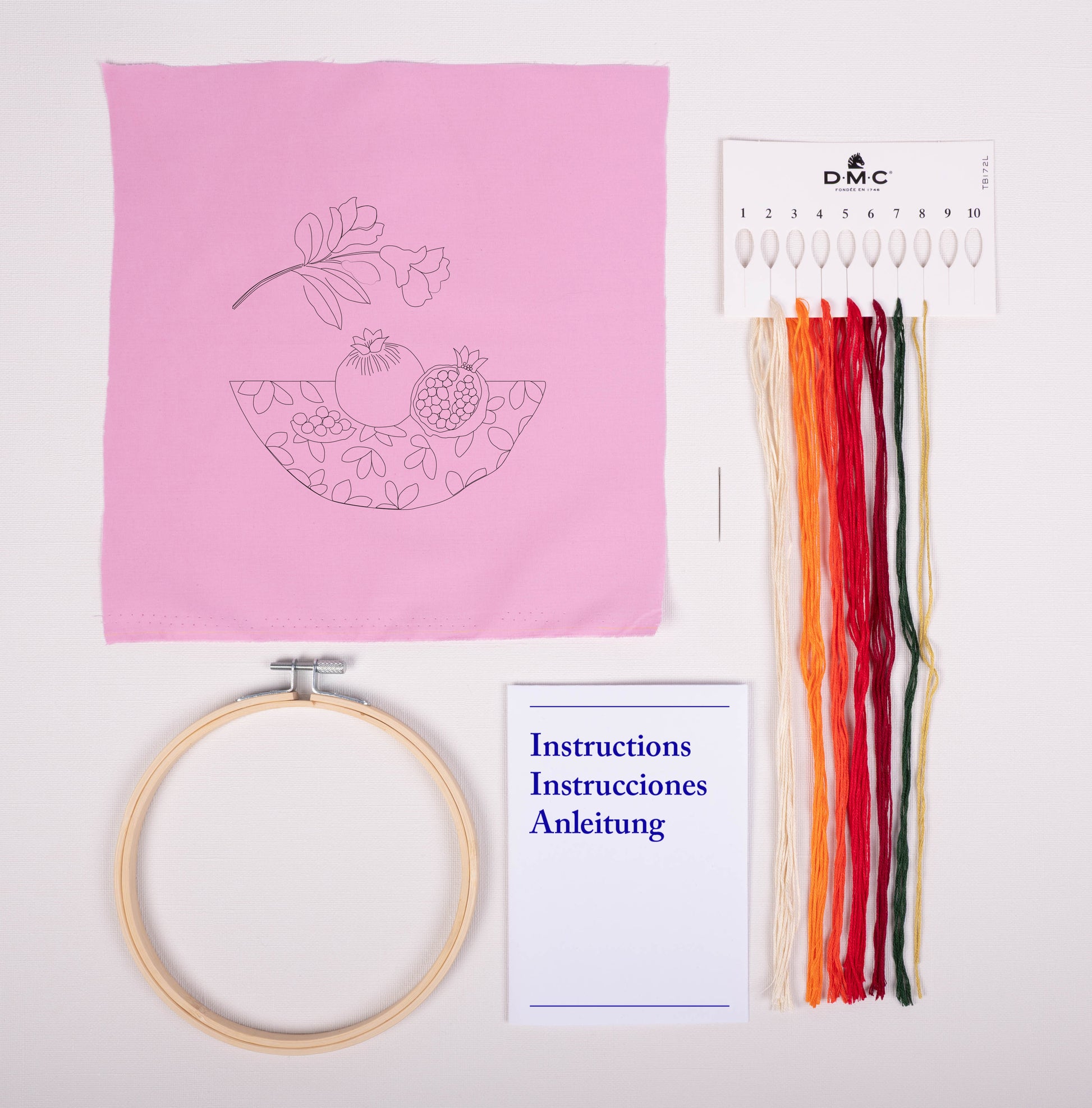 Contenido del kit de bordado DMC Granada con tela estampada rosa, hilos Mouliné Spécial, bastidor, aguja e instrucciones