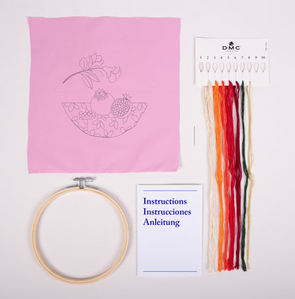 Contenido del kit de bordado DMC Granada con tela estampada rosa, hilos Mouliné Spécial, bastidor, aguja e instrucciones