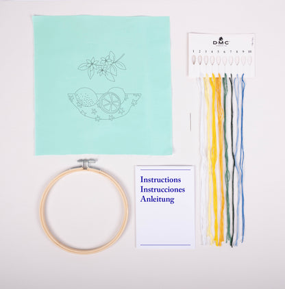 Contenido del kit de bordado DMC Los Limones con tela estampada turquesa, hilos Mouliné Spécial, bastidor, aguja e instrucciones