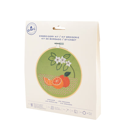 Kit de bordado DMC Naranja con diseño de naranjas y flores sobre tela verde y packaging de cartón