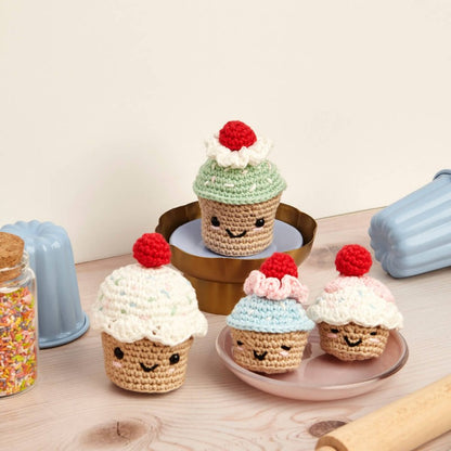 Kit de amigurumi de DMC para tejer cuatro cupcakes con cerezas en estilo kawaii, incluye hilos de algodón, ganchillo de 3 mm y ojitos de seguridad, ideal para decoración o regalo