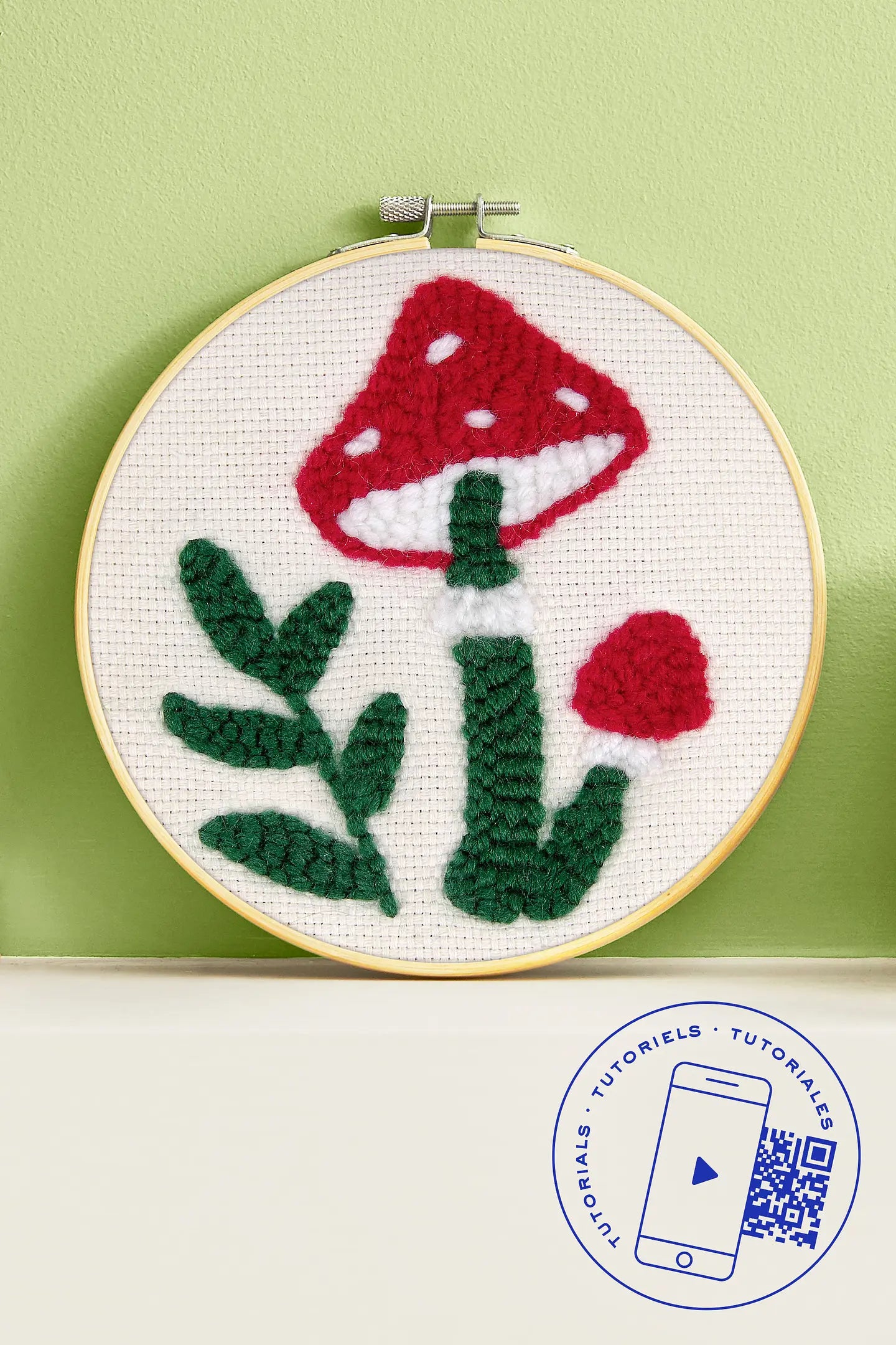 Kit de iniciación al punch needle DMC con diseño de seta roja en relieve sobre tela clara en bastidor de madera