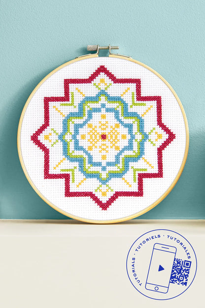 Kit de iniciación al punto de cruz DMC con diseño geométrico en rojo, azul, verde y amarillo en bastidor de madera