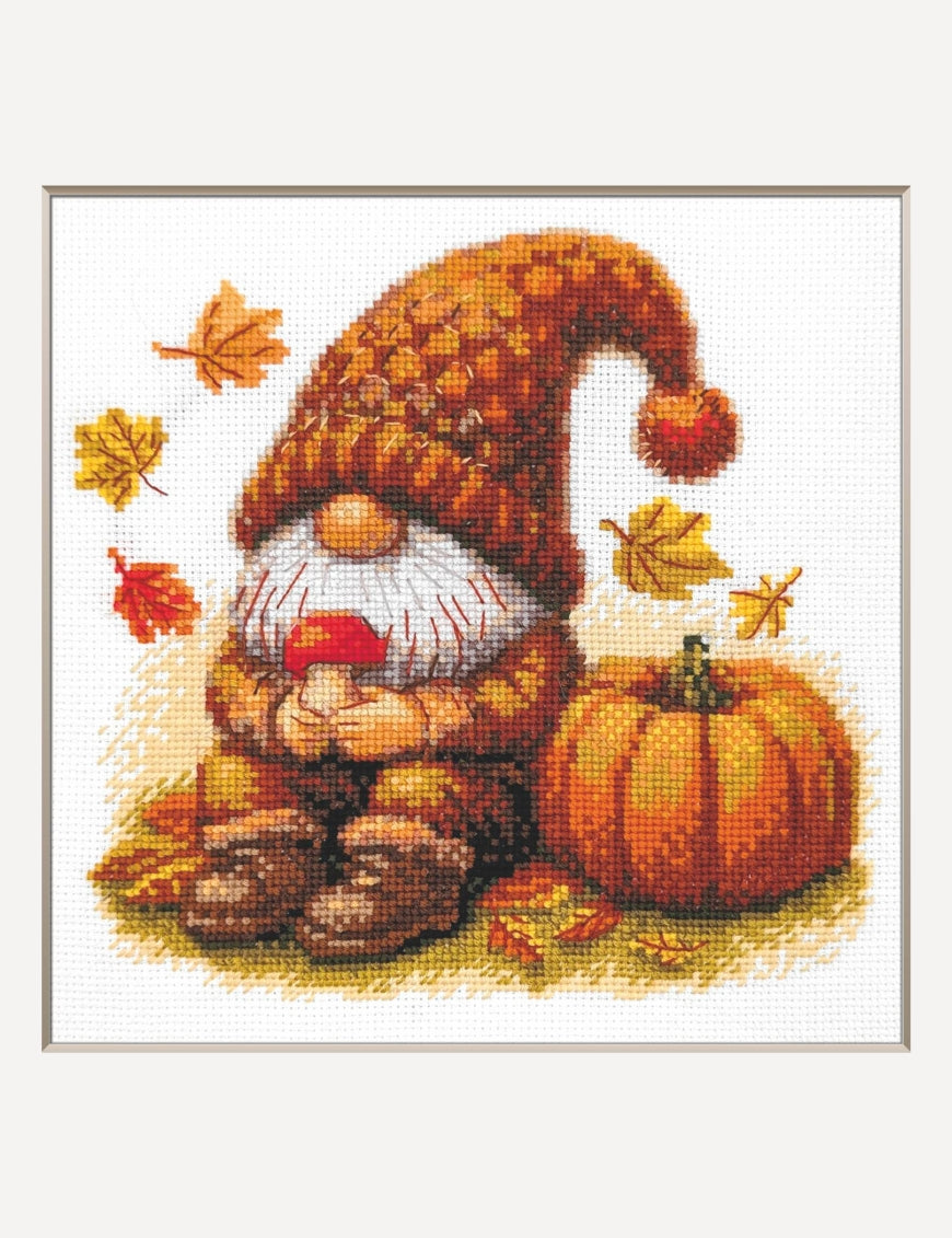 Kit de punto de cruz Aine Gnomo de la Cosecha, gnomo con gorro naranja junto a una calabaza y hojas de otoño