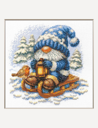Kit de punto de cruz Aine Gnomo Nevado, gnomo con gorro azul en un trineo con farolillo entre abetos nevados
