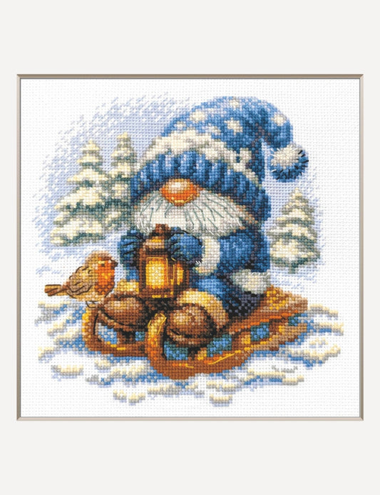 Kit de punto de cruz Aine Gnomo Nevado, gnomo con gorro azul en un trineo con farolillo entre abetos nevados