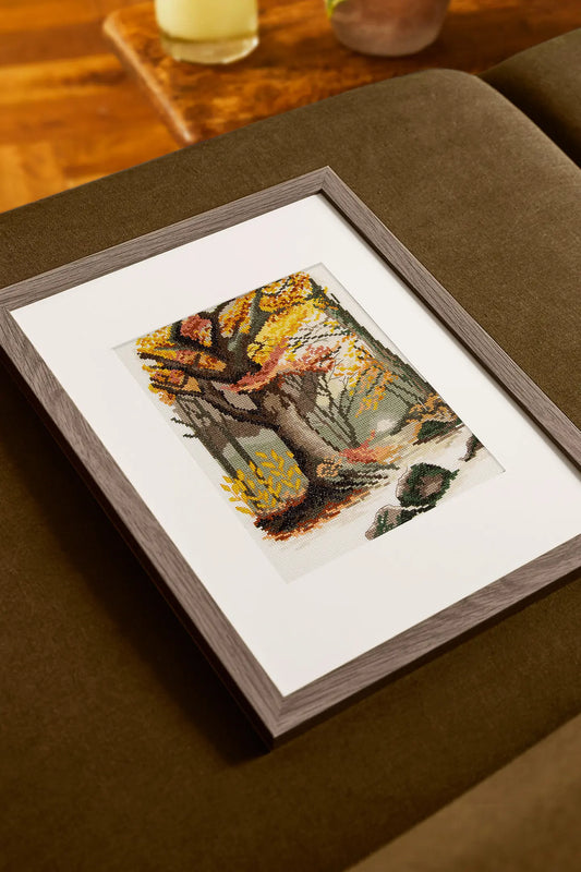 Kit de punto de cruz DMC Paisaje Otoñal con árbol en bosque de otoño en tonos cálidos sobre tela Aida.