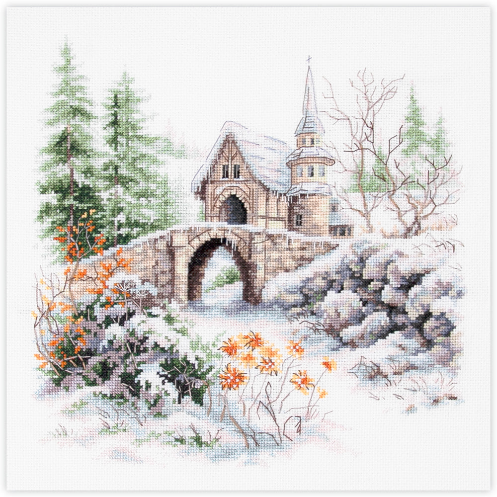 Kit de punto de cruz Magic Needle In Winter Dreams con diseño de puente de piedra y pequeña iglesia entre pinos nevados para bordado y decoración invernal.