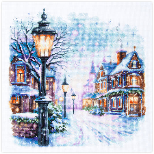 Kit de punto de cruz Magic Needle Snow in the City con diseño de calle nevada con faroles antiguos y casas iluminadas para bordado y decoración navideña.