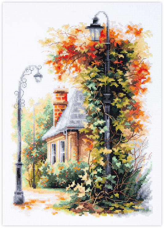 Kit de punto de cruz Magic Needle Quiet September con diseño de casita de otoño rodeada de enredaderas y faroles de hierro forjado para bordado y decoración.
