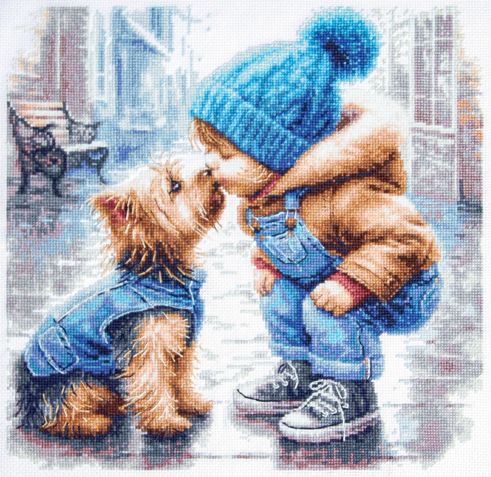 Kit punto de cruz Mi Primer Amigo Magic Needle con niño de gorro azul acariciando a un Yorkshire Terrier abrigado en escena invernal.