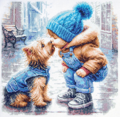 Kit punto de cruz Mi Primer Amigo Magic Needle con niño de gorro azul acariciando a un Yorkshire Terrier abrigado en escena invernal.