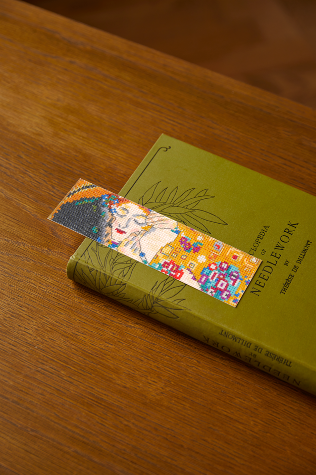Kit de punto de cruz DMC El Beso inspirado en la obra de Gustav Klimt con tela Aida 14ct y hilos Mouliné Spécial organizados para bordado.
