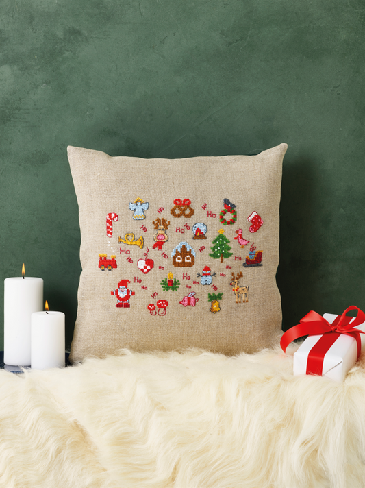 Kit de punto de cruz Permin Cojín Navideño con motivos festivos como Papá Noel, renos y regalos bordados sobre lino natural, incluye hilos e instrucciones.