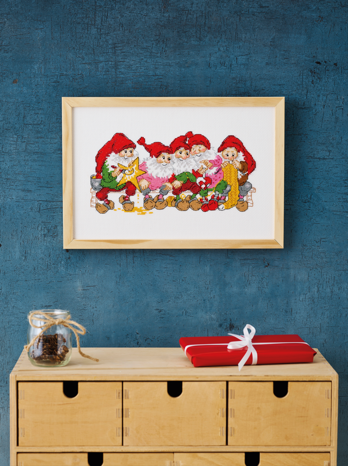 Kit de punto de cruz Permin Manualidades de Gnomos con grupo de gnomos elaborando manualidades navideñas sobre tela Aida blanca, incluye hilos, aguja e instrucciones.