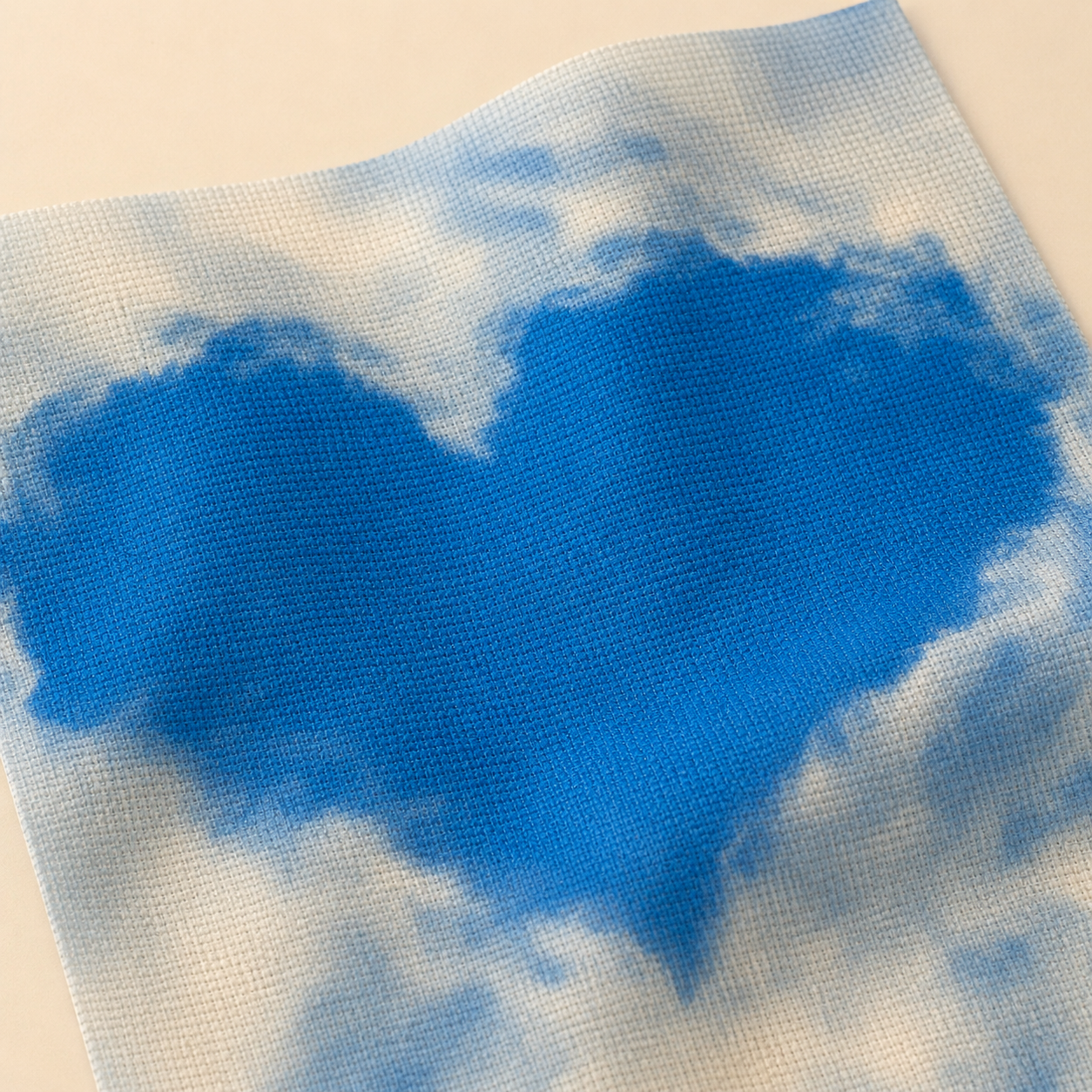 Detalle de tela Aida impresa Corazón de Nubes de Loisirs Créatifs con textura Aida 14 ct y diseño de cielo con corazón azul.