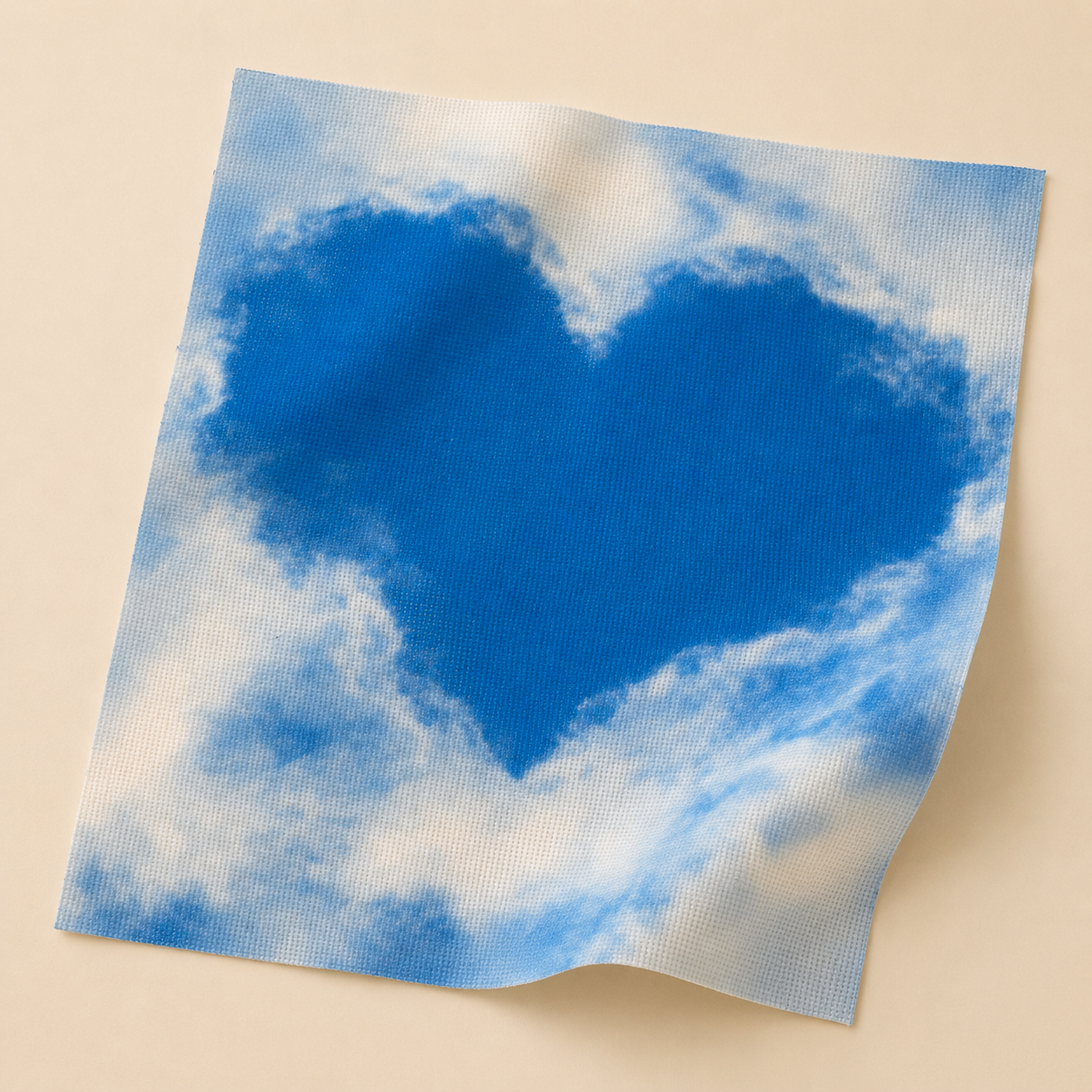Tela Aida impresa Corazón de Nubes de Loisirs Créatifs en perspectiva con diseño de corazón azul entre nubes sobre fondo claro.