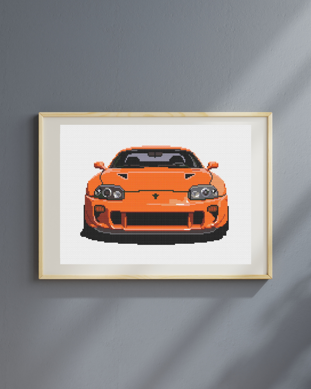 Patrón de punto de cruz del frontal de un Toyota Supra MK4 de los 90 de color naranja estilo Fast & Furious
